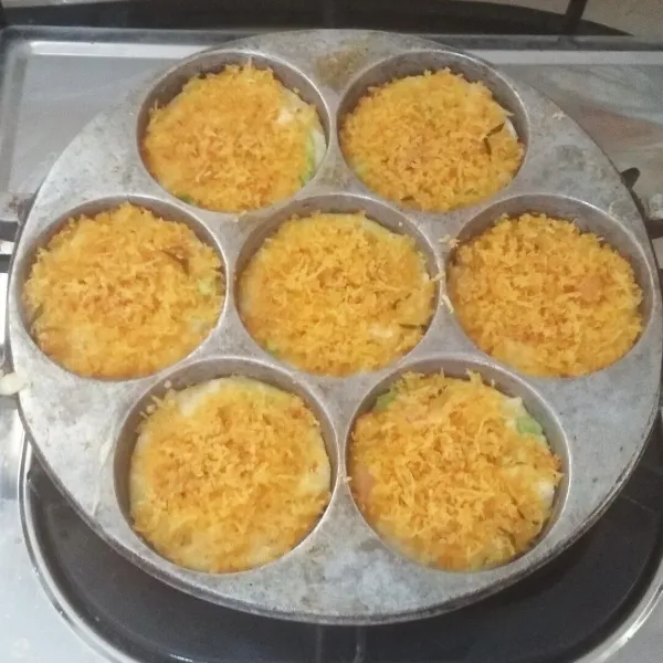 Beri serundeng / abon di atasnya, lalu taruh juga beberapa irisan cabai keriting hijau. Tutup wajannya, masak hingga bagian bawahnya berkulit dan berwarna kecoklatan.