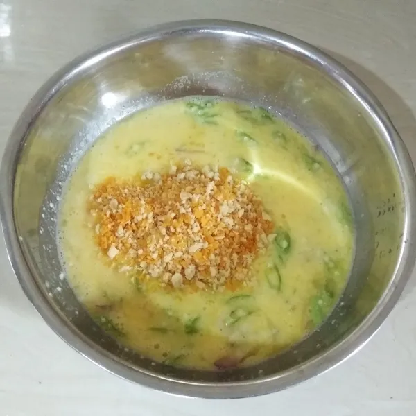 Masukan tepung panir dan minyak goreng, aduk rata lagi.