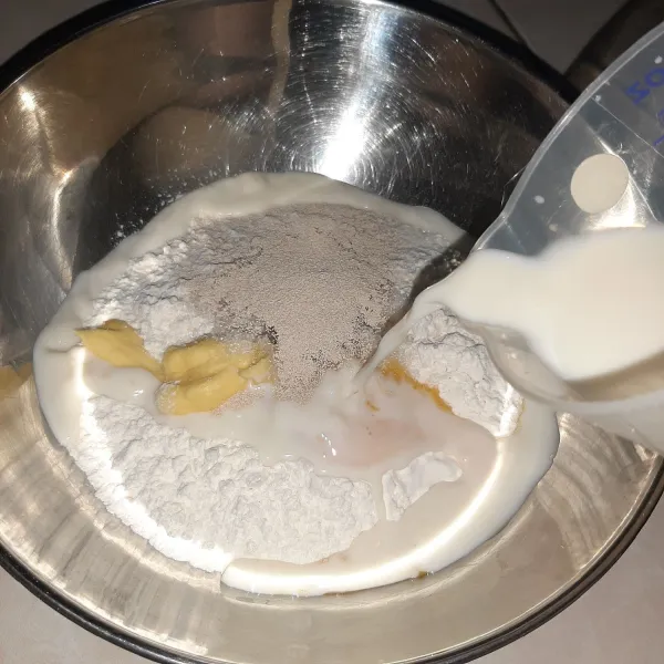 Tambahkan ragi dan susu cair. Aduk rata dan pastikan raginya masih aktif ya.