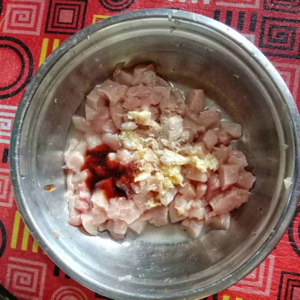 Potong ayam bentuk dadu lalu cuci bersih. Tambahkan saus tiram, garam, merica, bawang putih yang telah dihaluskan. Aduk rata dan remas-remas agar bumbu meresap. Diamkan 1 jam di kulkas.