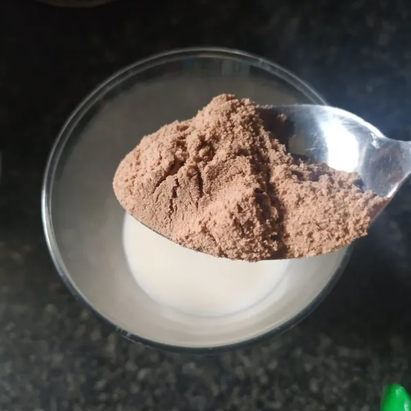 Beri cocoa bubuk dan aduk sampai larut. Kemudian beri es batu.