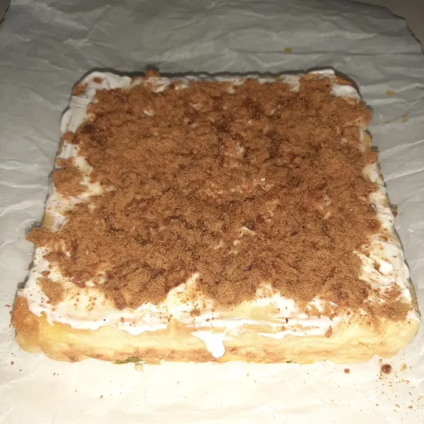 Keluarkan dari cetakan dengan bantuan baking paper yang lebih besar dari rotinya. Bagian yang warna warni ada di bawah. Lalu bagian yang polos diolesi dengan mayonaise, susu kental manis dan abon hingga rata.