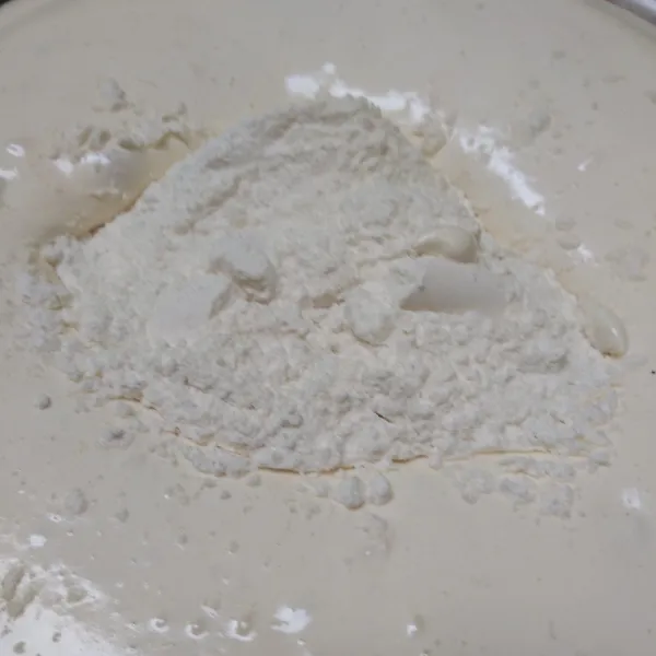 Masukkan tepung, kocok rata dengan speed rendah hingga rata. Tuang margarin cair, aduk rata menggunakan spatula hingga rata