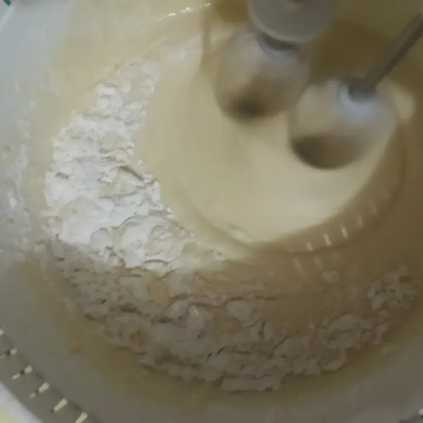 Masukkan tepung terigu, tepung maizena, baking powder, vanila bubuk, dan susu bubuk. Kocok dengan kecepatan rendah hingga tercampur rata.