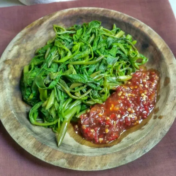 Sajikan kangkung rebus dengan sambal brambang asem.