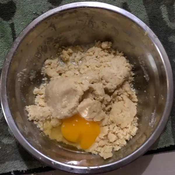 Setelah bertekstur seperti pasir tambahkan 1 telur lalu aduk rata (sisakan 2 telur untuk fla nya)