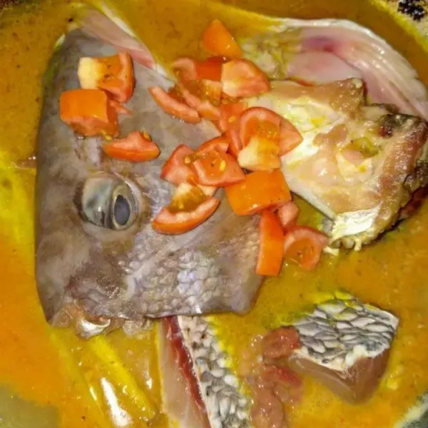 Beri irisan tomat dan air jeruk nipis. Masak dan tutup hingga kaldu ikan keluar.