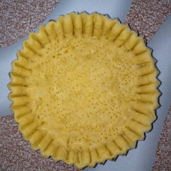 Uleni hingga tercampur rata kemudian pipihkan di atas cetakan pie. Tusuk kulit pie dengan garpu
