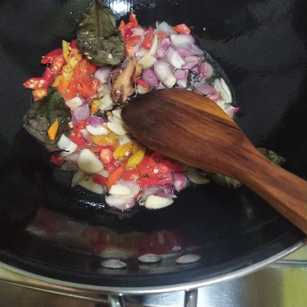 Tumis bumbu yang diiris yaitu bawang merah, bawang putih, cabai keriting, cabai rawit, lengkuas, dan daun salam. Tumis hingga layu dan harum.