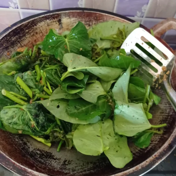 Masukkan kangkung dan pakis. Aduk rata sampai layu.