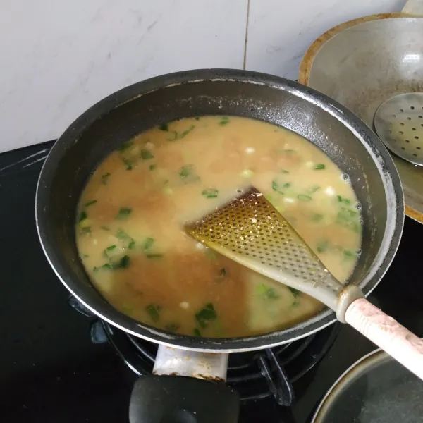 Masukkan bumbu halus ke dalam rebusan daging. Tambahkan kacang. Masak hingga mendidih. Masukkan daun bawang, seledri dan bawang goreng. Sajikan.