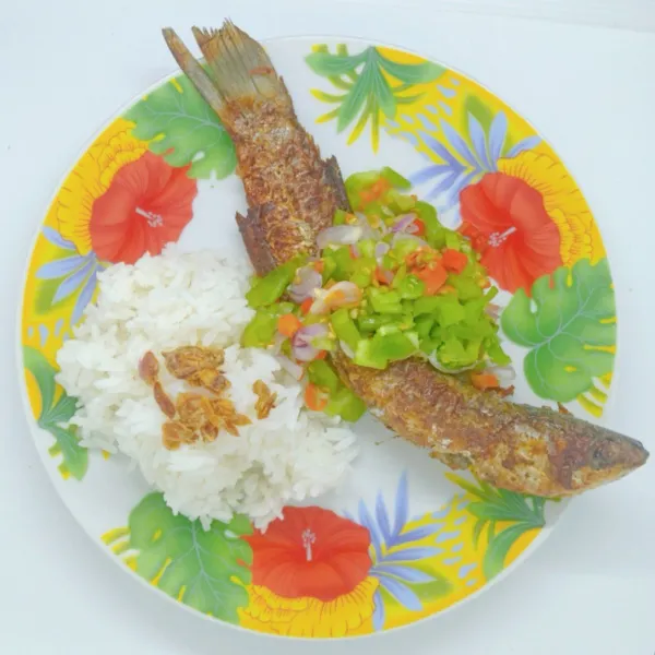 Sajikan ikan goreng bersama sambal dan nasi sebagai pelengkap.