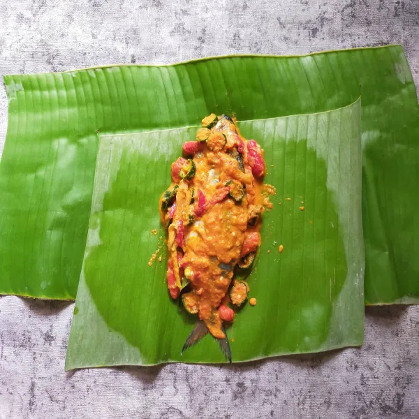 Lalu letakan adonan ikan, bungkus bentuk pepes, sematkan dengan lidi.