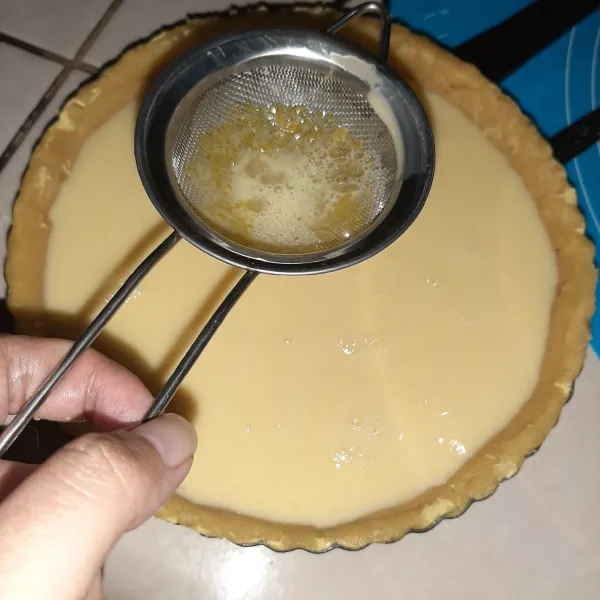 Saring isian ke atas adonan. Kalau masih ada sisa isian, bisa juga ditaruh di cup cupcake. Lalu panggang bersama. Rasa isian saja ini akan mirip creme brule.