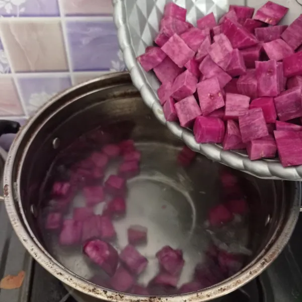 Didirikan air di panci. Masukkan ubi ungu dan masak sampai setengah empuk.