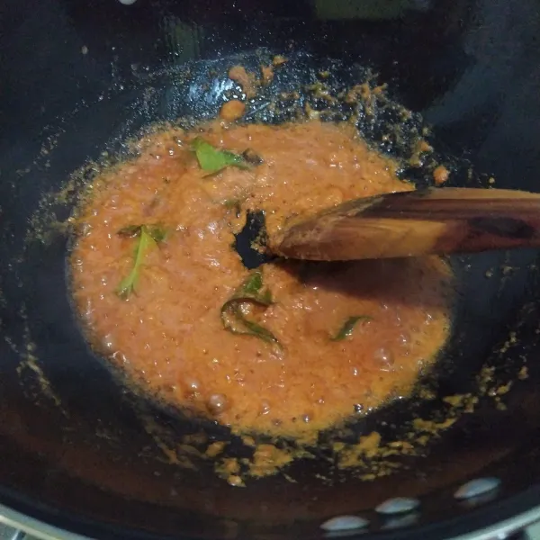 Tumis bumbu halus beserta daun jeruk dan daun salam hingga harum.