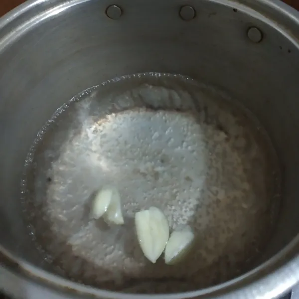 Masukkan air dan bawang putih geprek, masak sampai mendidih.