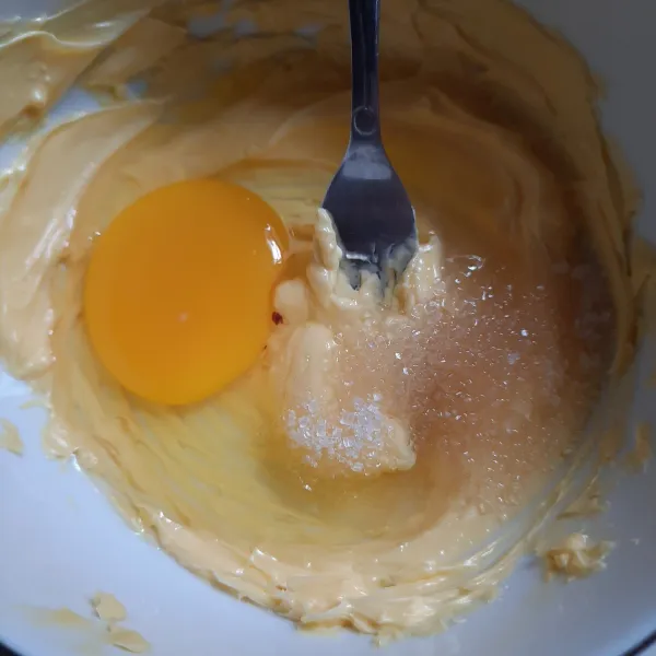 Masukkan telur dan gula. Aduk lagi hingga tercampur rata dan gula larut.