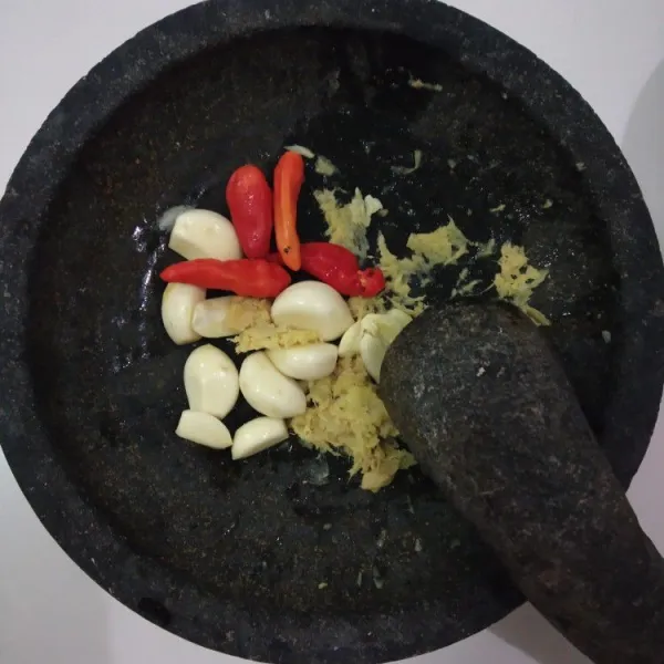 ulek bumbu yang dihaluskan seperti cabai, bawang putih, dan jahe.
