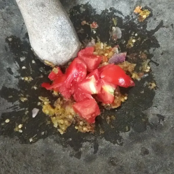 Masukkan tomat yang sudah dipotong potong. Ulek hingga halus. Lalu masukkan gula pasir, aduk rata. Koreksi rasanya.