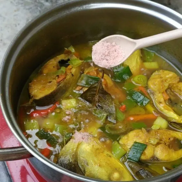 Bumbui ikan pallumara dengan garam dan kaldu jamur. Tes rasa