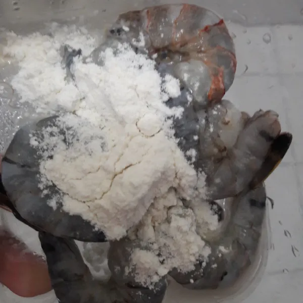 Ambil 1 sdm tepung terigu, masukkan ke dalam wadah berisi udang.