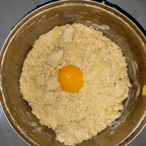 Tambahkan kuning telur, garam dan sedikit air. Uleni sama rata.
