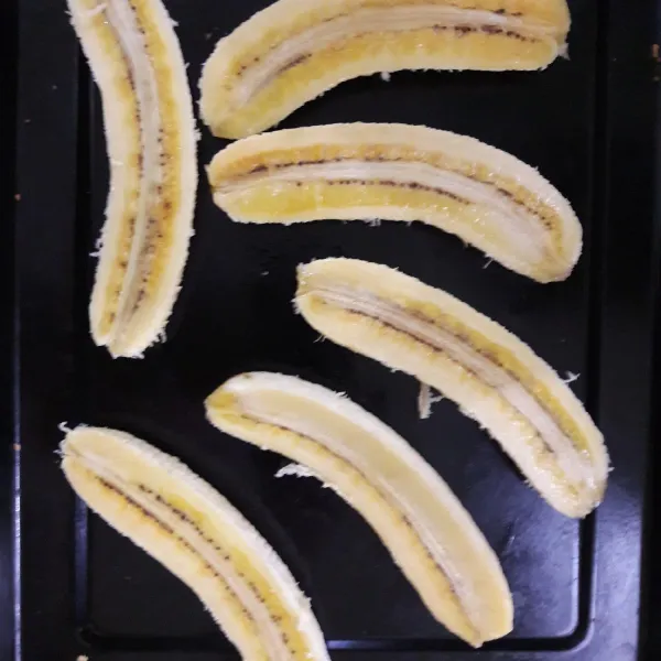 Belah pisang raja menjadi 2 bagian.