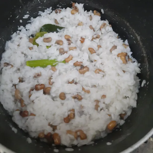 aduk rata nasi sampai air menyusut dan nasi setengah matang.