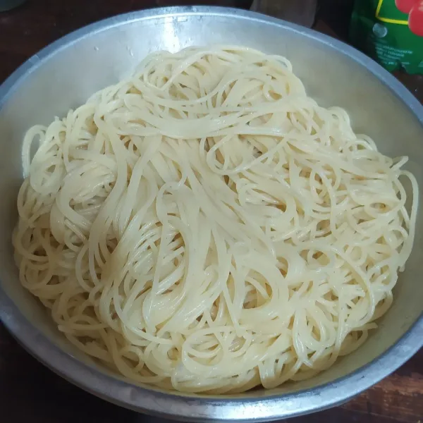 Angkat, lalu tiriskan. Beri 1/2 sdm minyak, aduk rata. (Jika tidak langsung dimasak siram dengan air dingin untuk menghentikan proses pemasakan, dan spaghetti bisa disimpan di kulkas).