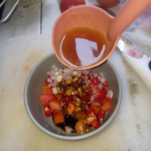 Siapkan wadah,masukan irisan tomat,bawang merah,cabe merah,garam,kaldu,kecap manis.Siram sambal colo dengan minyak panas.Aduk rata dan sajikan ikan nila beserta sambal colonya.