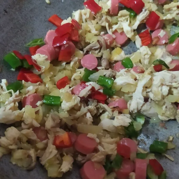 Masukkan ayam rebus, sosis dan cabe merah-hijau, aduk-aduk hingga ayam dan sosis tanak.