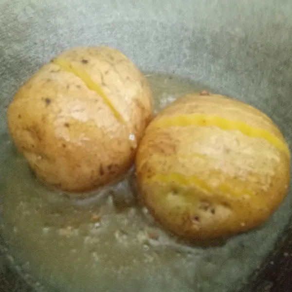 Goreng kentang dengan minyak sambil disiram-siram supaya garing merata.
