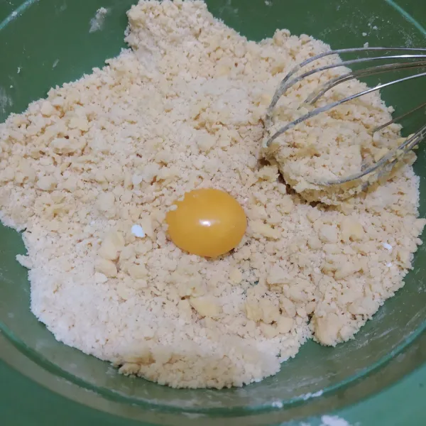 Campurkan tepung terigu, gula halus dan margarin, lalu aduk rata. Tambahkan kuning telur. Diamkan adonan 15 menit di dalam kulkas.