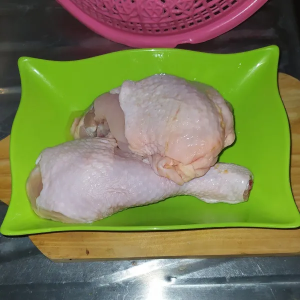 Cuci bersih ayam lalu potong menjadi dua bagian.