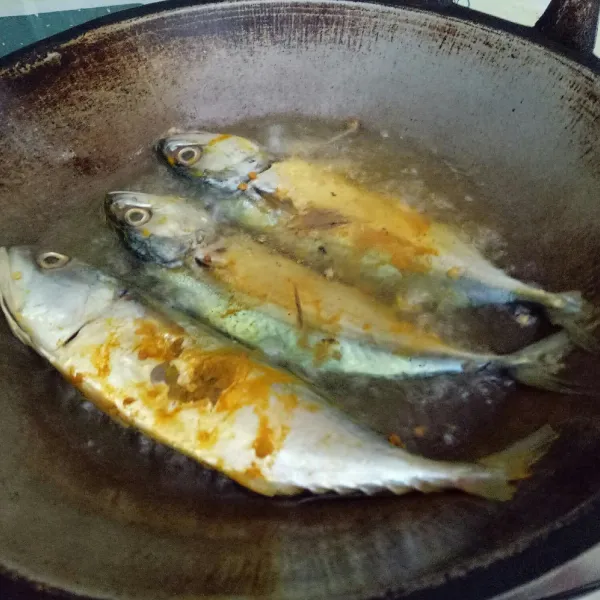 Panaskan minyak banyak, lalu goreng ikan hingga garing di kedua sisi.