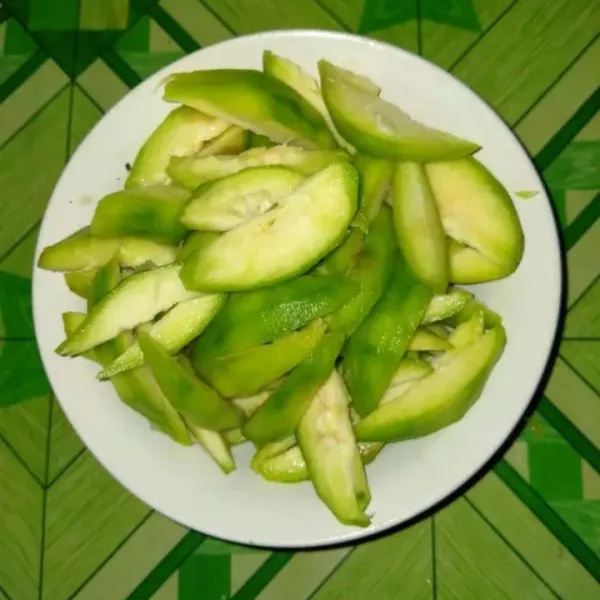 Kupas kulit buah kedondong lalu cuci dan potong sesuai selera.