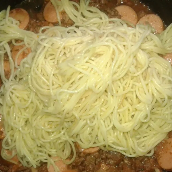 Masukkan spaghetti yang sudah direbus. Aduk rata. Sajikan dengan topping keju cheddar yang diparut (jika suka).
