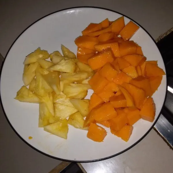 Kupas buah mangga. Cuci buah mangga dan nanas kemudian potong sesuai selera.