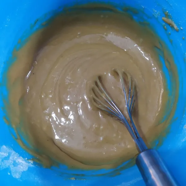 kocok kuning telur dan vanila bubuk menggunakan whisk hingga agak pucat, masukkan minyak kelapa, aduk rata, masukkan larutan gula dan tepung terigu, aduk rata hingga seperti pasta.