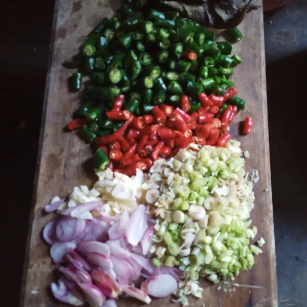 Siapkan tatakan lalu potong cabe merah, cabe hijau, bawang merah, bawang putih dan serai dipotong halus