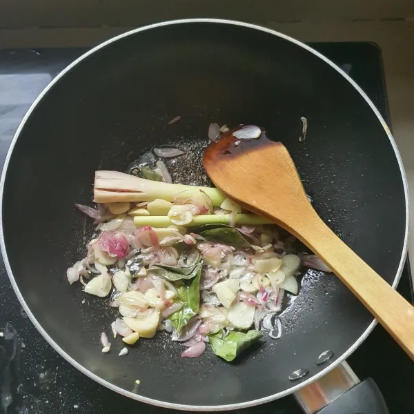 Tumis bumbu iris dengan minyak goreng, hingga layu. Tambahkan serai dan daun salam.