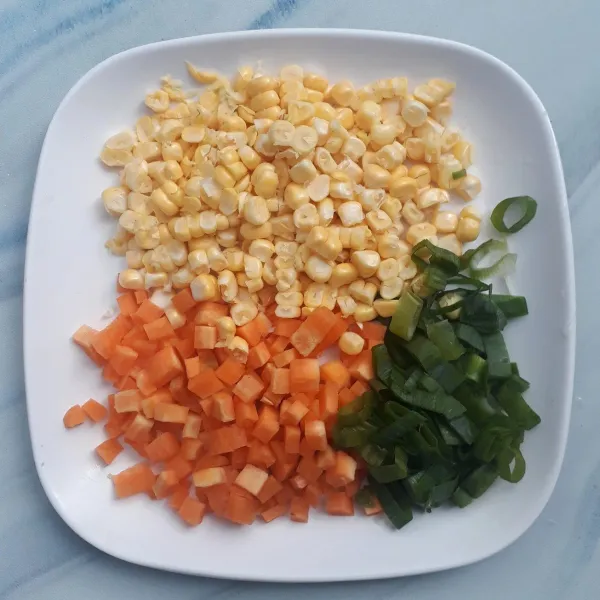 Wortel di potong dadu kecil, jagung manis disisir dari bonggolnya dan daun bawang diiris agak tipis