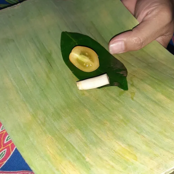 Siapkan daun pisang yang sudah dibersihkan dan dipotong persegi panjang. Masukkan potongan serai, daun dalam dan tomat ceri. Jumlah ketiga bahan ini disesuaikan dengan jumlah bungkusan yang dibuat ya.