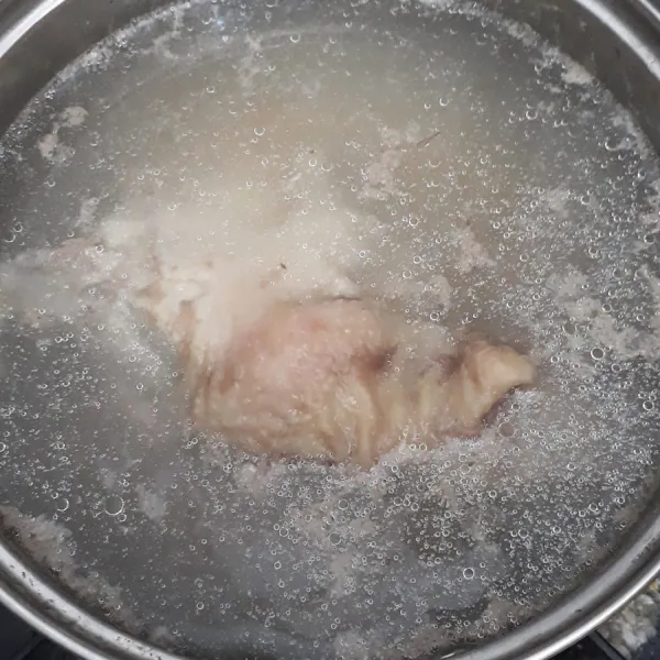 Rebus daging ayam dan air hingga mendidih lalu kecilkan api. Masak hingga daging ayam berubah warna