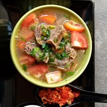 Penyajian, beri potongan daging, tomat, secukupnya dain bawang dan seledri, lalu tuang kuahnya. Sajikan bersama sambal rawit dan nasi hangat.