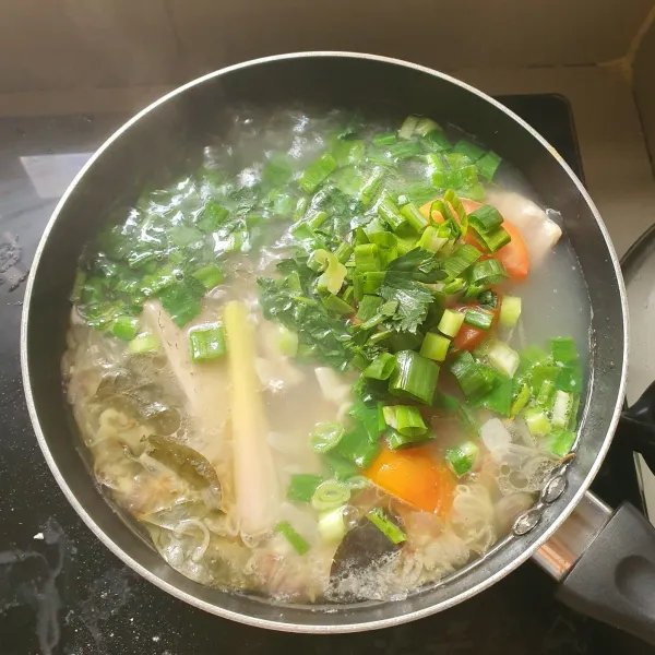 Setelah mendidih tambahkan potongan daun seledri, daun bawang dan tomat.