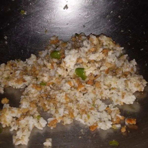 Masukan nasi. Aduk hingga nasi tidak menggumpal dan tercampur rata. Sajikan nasi tutug oncom dengan ayam goreng dan lalapan.