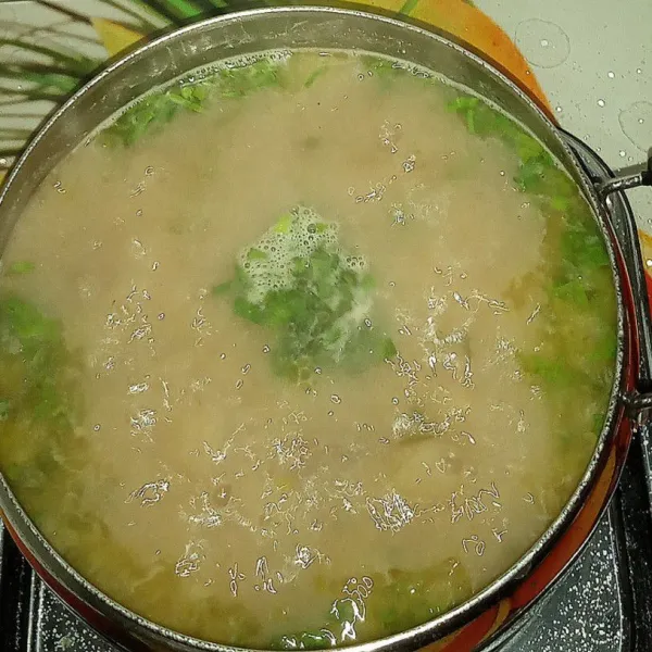 Sesaat sebelum diangkat, masukkan sebagian irisan daun seledri dan daun bawang. Matikan api