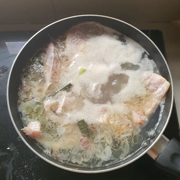 Masukkan ikan yang telah dilumuri air perasan jeruk nipis dan garam. Tambahkan wortel yang dipotong-potong.